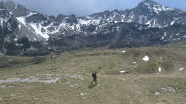 Uzun yürüyüşe çıkan kimse çimenli yamaç gidiş