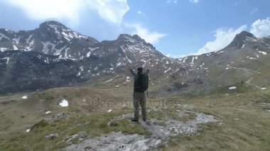 Uzun yürüyüşe çıkan kimse üstte duruyor ve zafer hareketle ortaya çıkar ellerini tutar