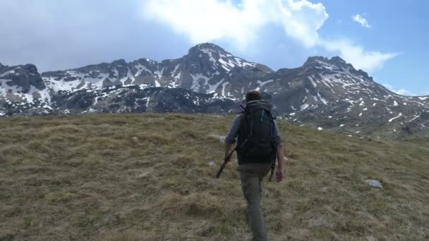 Hiker går till toppen och höjer armarna upp i seger gest — Stockvideo