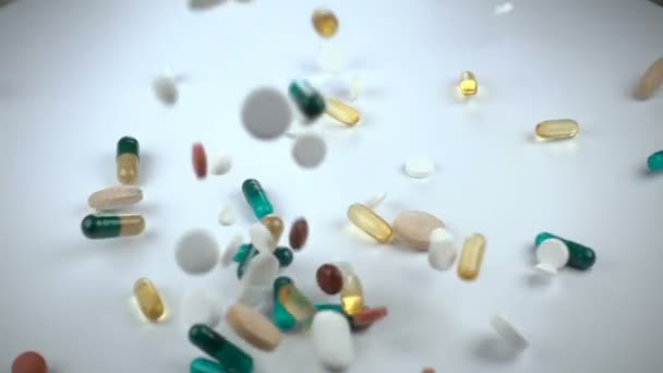Suuri ja monipuolinen valikoima farmaseuttisia lääkkeitä tai vitamiinilisiä putoaa valkoista taustaa vasten. — kuvapankkivideo