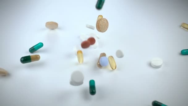 Uma grande e variada variedade de medicamentos ou suplementos vitamínicos cai contra um fundo branco — Vídeo de Stock