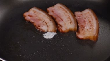 Yumurtayı sıcak bir kızartma tavası pastırma ile düşüyor