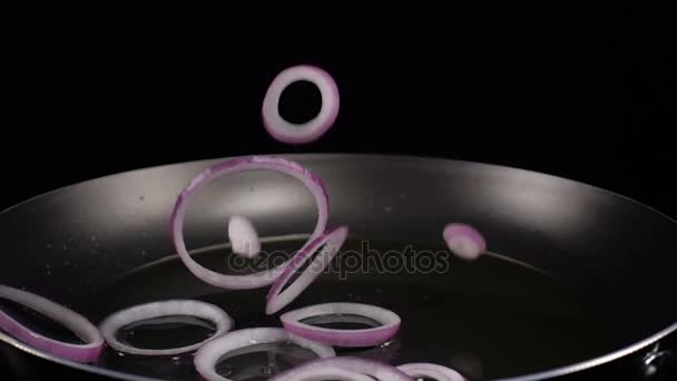 Δαχτυλίδια μωβ κρεμμύδια που πέφτουν στο τηγάνι — Αρχείο Βίντεο