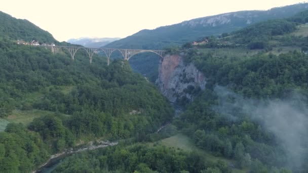 Vista aérea del puente del arco de Durdevica Tara en las montañas, uno de los puentes automovilísticos más altos de Europa . — Vídeo de stock
