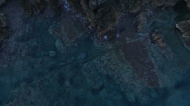 Sakin bir deniz yüzeyi kayalar tarafından