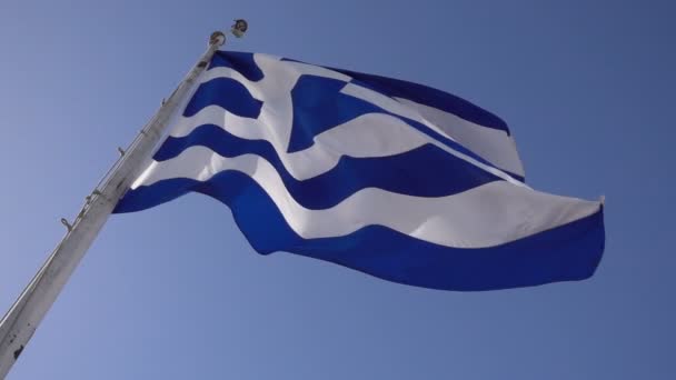 Yunan bayrağı mavi gökyüzüne karşı sallayarak — Stok video