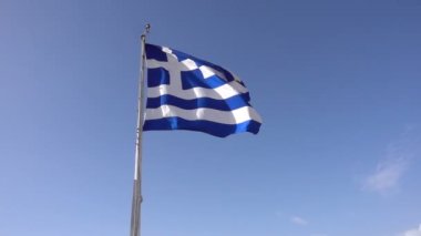 Yunan bayrağı mavi gökyüzüne karşı sallayarak