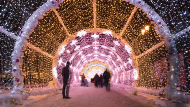 Menschen, die durch den Lichttunnel des neuen Jahres und der Weihnachtsfeiertage in der Moskauer Innenstadt laufen — Stockvideo