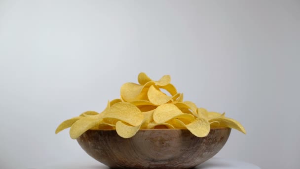 Papas fritas en cuenco de madera girando sobre un fondo blanco — Vídeo de stock