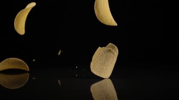 Potato chips in een vrije val op een zwarte achtergrond — Stockvideo