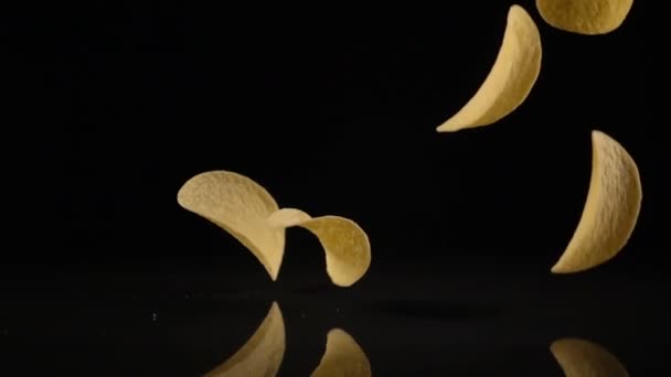 Картопляні чіпси у вільному падінні на чорному тлі — стокове відео