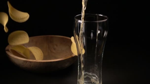 Papas fritas se vierten en un tazón de madera y la cerveza se vierte en un vaso — Vídeo de stock