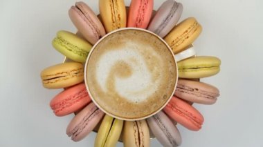 Bir fincan kahve etrafında pastel macarons
