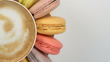 Bir fincan kahve etrafında pastel macarons