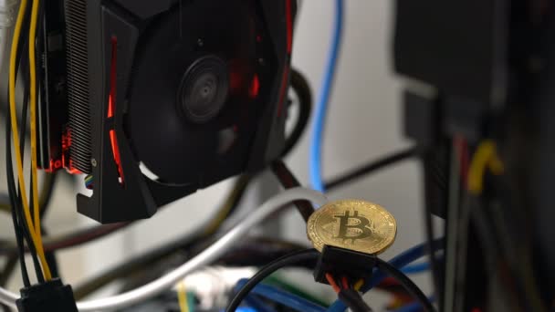 Bitcoin no fundo de uma placa gráfica em um rack para mineração de criptomoedas — Vídeo de Stock