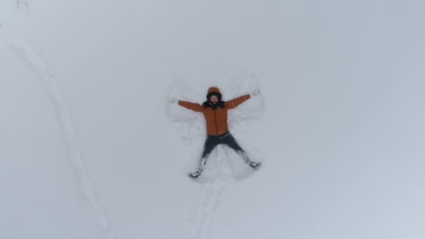 Junger Mann bastelt Schnee-Engel — Stockvideo