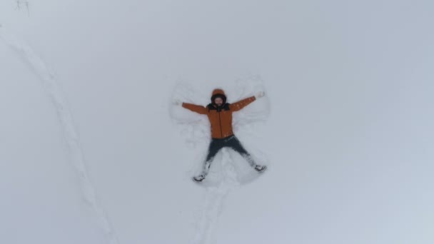 Jeune homme faisant des anges de neige — Video