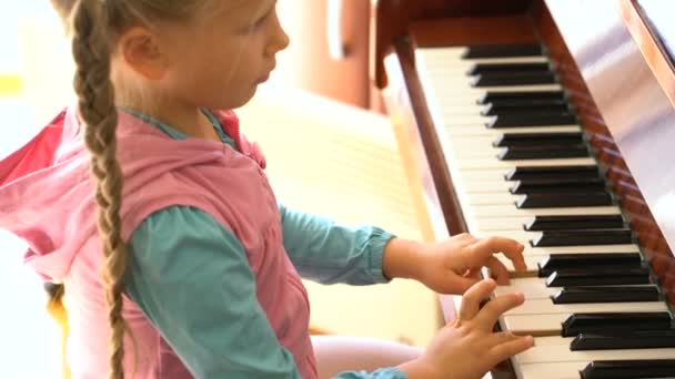 Lilla flickan lär sig att spela piano — Stockvideo