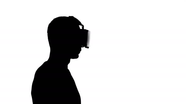 Silhouette di un uomo in occhiali di realtà virtuale guardando un video — Video Stock