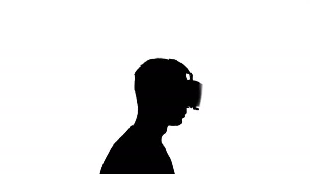 silhouette of a man in virtual reality glasses watching a video