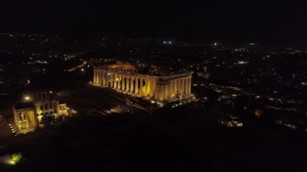 Vídeo nocturno aéreo de la icónica colina de la antigua Acrópolis y el Partenón por la noche, centro histórico de Atenas — Vídeo de stock