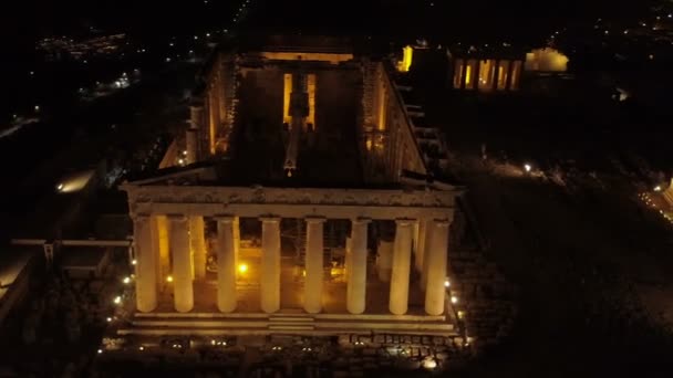 Vídeo nocturno aéreo de la icónica colina de la antigua Acrópolis y el Partenón por la noche, centro histórico de Atenas — Vídeo de stock