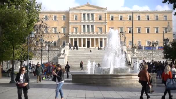 Athens, Griekenland - 15 November 2017: Lokale bevolking en toeristen lopen op het Syntagmaplein in Griekenland met de bouw van het Griekse Parlement achter hen — Stockvideo