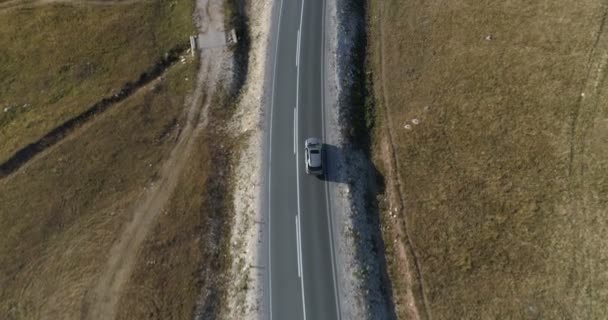 Повітряний вид на розкішний автомобіль, що їде по заміській дорозі — стокове відео