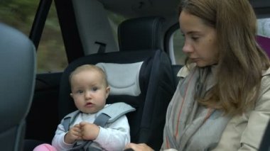 Anne ve bebek arka koltukta arabaya biniyorlar.