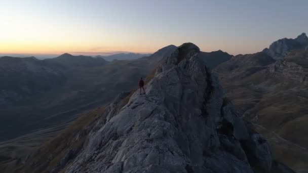 Повітряний епічний знімок чоловіка, що стоїть на краю гори — стокове відео