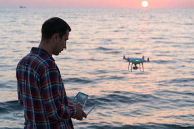 Adam kumsala insansız hava aracı fırlatıyor.