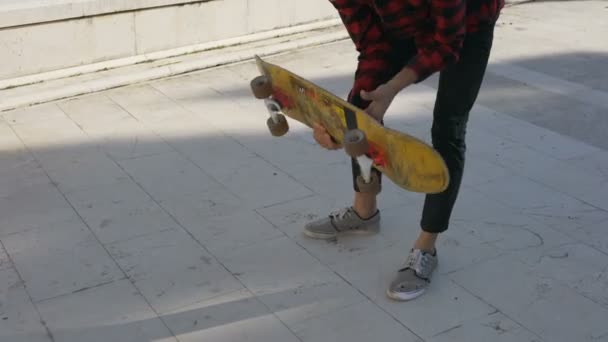 Молодий чоловік скейтбордист показує, як скейтборд повинен обертатися, а потім намагається виконати трюк — стокове відео