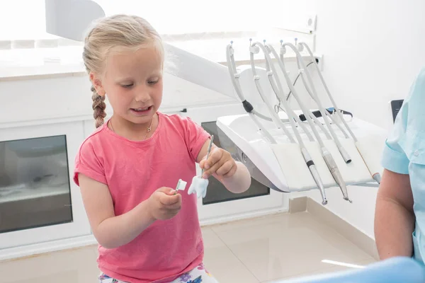Маленька дівчинка сидить у стоматологічному кабінеті — стокове фото