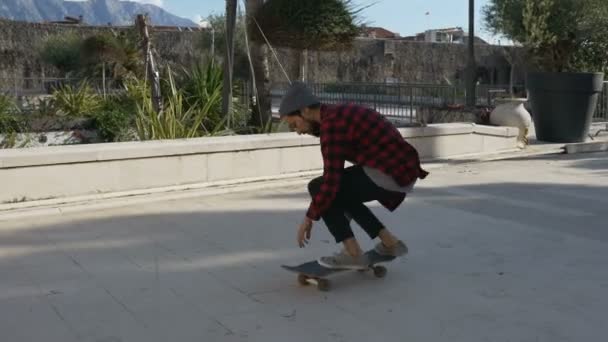 Молодий чоловік скейтбордист виконує кілька трюків — стокове відео