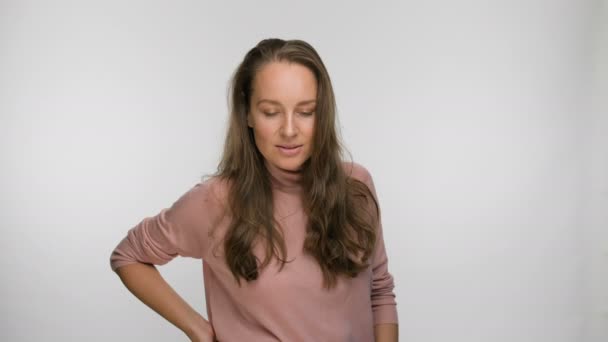 Retrato de una mujer coqueta y sonriente en una blusa rosa — Vídeos de Stock