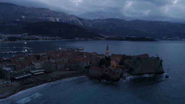 Luftaufnahme der Küstenstadt Budva mit mittelalterlichen Gebäuden in der Abenddämmerung — Stockvideo