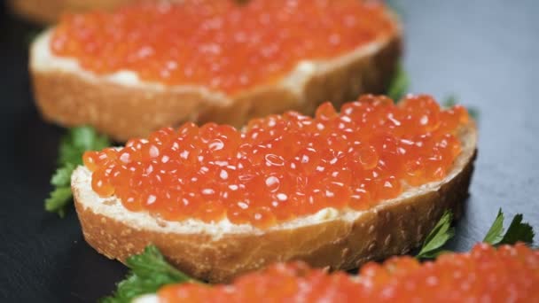 Sanduíches com caviar vermelho no fundo de pedra escura — Vídeo de Stock