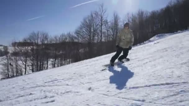 晴れた日にスキーで山を楽しむスノーボーダーに乗る — ストック動画