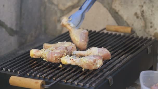 Man zet kippenpoten op de grill — Stockvideo