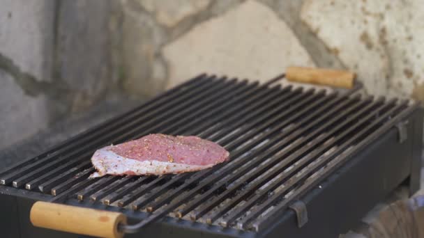 Man puts beef steaks on the grill — Stock Video