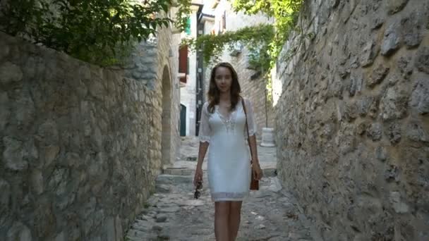 Młoda kobieta spaceruje ulicami starego miasta Ulcinj — Wideo stockowe