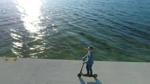 Kendine güvenen genç iş adamı modern ulaşım elektrikli scooterıyla işe gidiyor. Tekne iskelesinde scooter 'la gezen yakışıklı iş adamı.. — Stok video