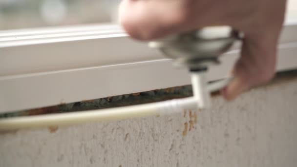 Använda polyuretanskum för att fylla luckor under installation av ett fönster. — Stockvideo