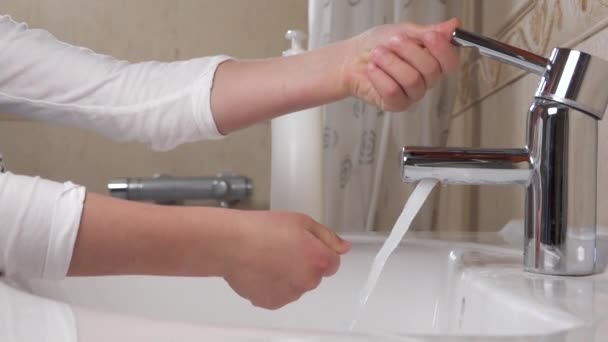 Профилактика коронавируса COVID-19. Мытье рук. Ребёнок моет руки проточной водой и мылом . — стоковое видео