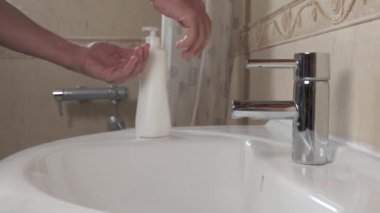 Koronavirüsü önleme COVID-19. Yıkama. Adam ellerini akan su ve sabunla yıkıyor..