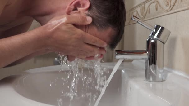 Homem lava o rosto com água corrente e sabão . — Vídeo de Stock