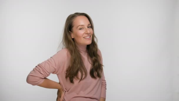 Retrato de uma mulher flertando e sorrindo em uma blusa rosa — Vídeo de Stock