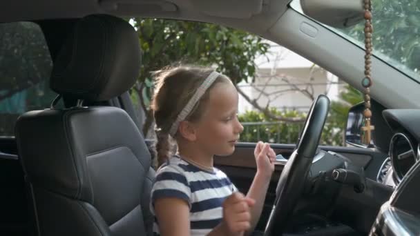 Chica sentada en un coche y bailando escuchando música — Vídeos de Stock