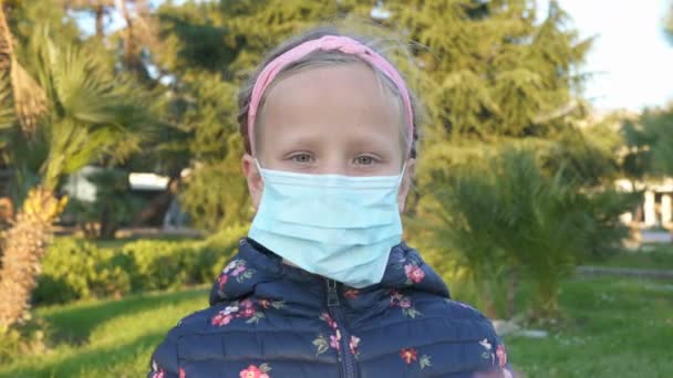 Κορίτσι βγάζει μια ιατρική μάσκα στο δρόμο και χαμογελάει — Αρχείο Βίντεο