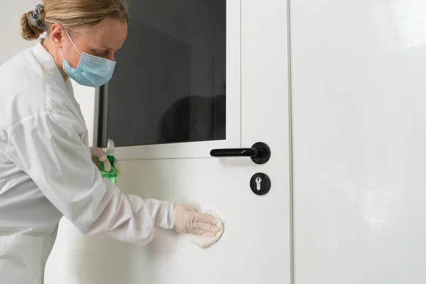 Mulher usando limpeza úmida e álcool desinfeta spray desinfeta maçaneta da porta. Desinfecção, limpeza e cuidados de saúde, Anti Coronavirus COVID-19 — Fotografia de Stock